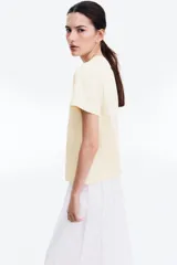 Remera color crema de algodón, de corte amplio, con cuello redondo y mangas cortas.