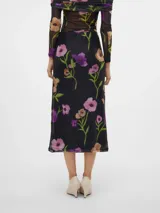 Falda midi negra de tul con estampado floral en tonos rosa, violeta y naranja. Tiene cintura alta con cordón ajustable y abertura lateral.