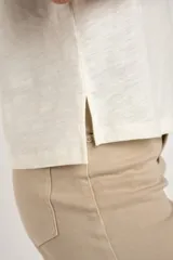 Remera color crudo de algodón peinado con cuello en V y mangas cortas.