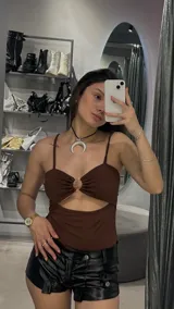 Body marrón con breteles finos, escote con abertura circular y recorte en el abdomen.