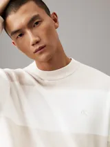 Sweater Calvin Klein de punto de algodón a rayas horizontales en tonos beige y blanco, con logo CK bordado en el pecho.