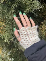 Par de mitones blancos tejidos a crochet con diseño calado.