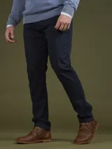 Pantalón de vestir negro, de corte recto, con bolsillos laterales y traseros. Se ajusta a la cintura con cinturón de cuero marrón.