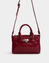 Cartera mini city de cuerina color rojo, con doble asa corta, correa regulable y desmontable, cierre superior y broche metálico de corazón.
