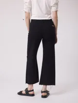 Pantalón de jean negro, tiro alto y pierna ancha con terminación desflecada.