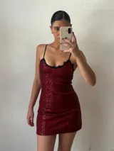 Vestido corto de fiesta color bordó, con lentejuelas, breteles finos y escote con encaje negro.