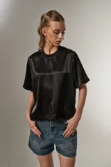 Blusa negra de poliéster con cuello redondo y corte ancho.