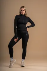 Conjunto deportivo negro compuesto por calza tiro alto y campera con cierre frontal.