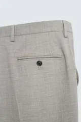 Pantalón de vestir gris claro, de corte recto, confeccionado en tejido con lana. Cuenta con bolsillos frontales y traseros de doble vivo con botón. Cierre frontal con cremallera y botón.