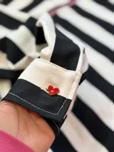 Camisa oversize de jean rayado blanco y negro con bolsillo con bordado de corazón con fuego y botones de acrílico en forma de corazón.