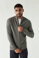 Campera tejida azul marino con cuello alto, cierre frontal y puños acanalados con detalle de línea roja.