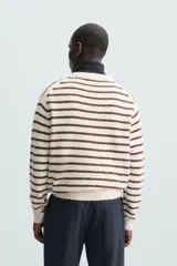 Jersey de punto color crudo con rayas horizontales marrones, cuello redondo y manga larga.