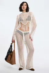 Pantalón de crochet color blanco, de tiro alto y corte acampanado.