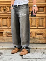 Pantalón de jean gris oscuro con corte amplio y estampado con el logo de la marca en la pierna izquierda.