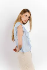 Blusa blanca de algodón con escote en V, volados en el frente y mangas cortas.