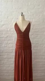 Vestido largo de microtul color terracota, con breteles finos, escote en V pronunciado y fruncido en la cintura.