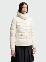 Chaqueta puffer Moncler modelo Glareins en color blanco, con diseño acolchado, cuello alto y capucha. Presenta cierre frontal con botones a presión, un bolsillo con solapa en el pecho y bolsillos laterales con cierre de cremallera.