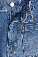 Short de denim de algodón levemente elástico con bolsillos parche delanteros y traseros. Modelo de tiro alto con cierre y botón.