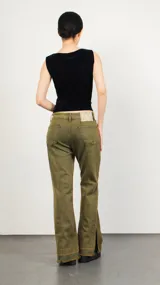 Pantalón jean negro de corte acampanado con abertura en los laterales.