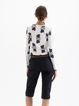 Remera de morley de punto color blanco con estampado de cerezas en azul oscuro, de calce al cuerpo, escote redondo y mangas largas.