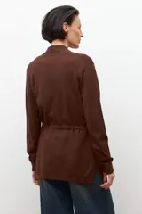 Ruana de tejido de punto color marrón chocolate, con cuello redondo y mangas largas.