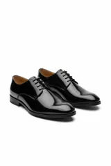 Zapato de vestir acordonado color marrón oscuro, de cuero liso con suela de goma negra.