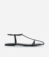 Sandalias planas negras con tiras finas, puntera cuadrada y cierre con hebilla en el tobillo.