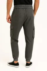Pantalón babucha color beige con cintura elástica ajustable con cordón, bolsillos laterales y corte holgado.