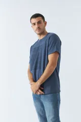 Remera azul de algodón con cuello redondo y estampado frontal con nombres de ciudades: Berlín, Nueva York, Dubai, París y Shanghái.