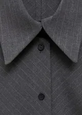 Minivestido gris con estampado de raya diplomática, diseño cruzado con cierre de botones en la parte delantera, manga larga con puños abotonados, cuello camisero y diseño entallado.