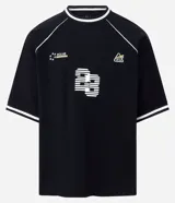 Remera deportiva de algodón, color negro, con corte oversized, cuello redondo y mangas cortas. Presenta ribetes contrastantes en blanco en el cuello y los bordes de las mangas. Tiene un estampado localizado en el pecho con tipografía en relieve y un pequeño logo en el lateral superior.