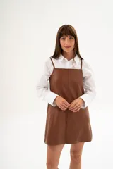 Vestido corto de cuero color caramelo, con breteles finos regulables y corte recto.