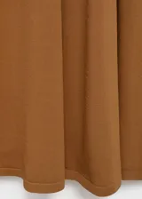 Vestido largo de tejido de punto fino color camel, sin mangas y con cuello redondo. Presenta un corte evasé que se ajusta al cuerpo en la parte superior y cae con vuelo en la falda.