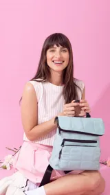 Mochila negra de nylon capitoneada con bolsillo principal con cierre, dos bolsillos frontales con cierre y asa superior.