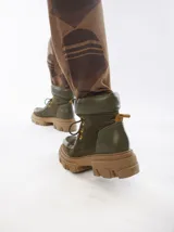 Botas de caña media color marrón de cuero gamuzado, con suela track y cordones rojos.