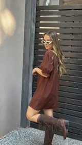 Vestido corto marrón con escote cuadrado, mangas cortas abullonadas con elástico y corte recto.