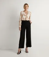 Pantalón negro tipo pantalona en viscosa y lino, con pliegues, trabillas y cinturón con hebilla.