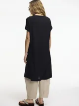 Vestido largo color beige de tejido de punto, con mangas cortas y tajo frontal.