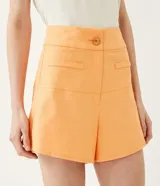 Short acampanado color naranja, de lino, con bolsillos y botón decorativo.