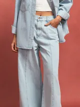 Pantalón de jean celeste de corte acampanado con costuras verticales en el frente.