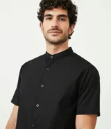 Camisa negra de algodón con corte slim, cuello mao, manga corta y abotonadura frontal.