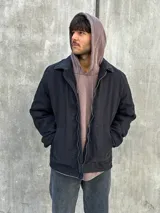 Campera negra con cierre frontal, cuello camisero y bolsillos laterales.