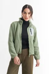 Campera negra de corderito con cierre frontal y cuello alto. Tiene un bolsillo con cierre en el pecho y bolsillos laterales.