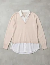 Buzo de hilado fino color beige con cuello y ruedo de gasa blanca que simula una camisa debajo. Presenta escote en V y mangas largas.