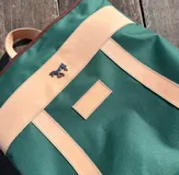 Mochila de lona azul con detalles en cuero, incluye mangos regulables para mayor comodidad.
