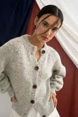 Cardigan gris de punto con botones frontales, de mangas largas y corte holgado.