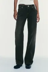 Pantalón de jean celeste claro, de tiro bajo, corte wide leg y largo hasta el tobillo. Tiene cinco bolsillos, cierre frontal con cremallera y botón metálico.