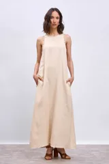 Vestido largo color crema, de corte recto y sin mangas, con detalle de bordado calado en cuello y sisas.