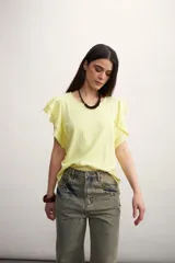 Remera color amarillo pastel con cuello redondo y mangas cortas con volados.