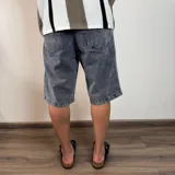 Bermuda de jean de corte ancho y largo, color negro lavado, con tiro medio y bolsillos delanteros y traseros.